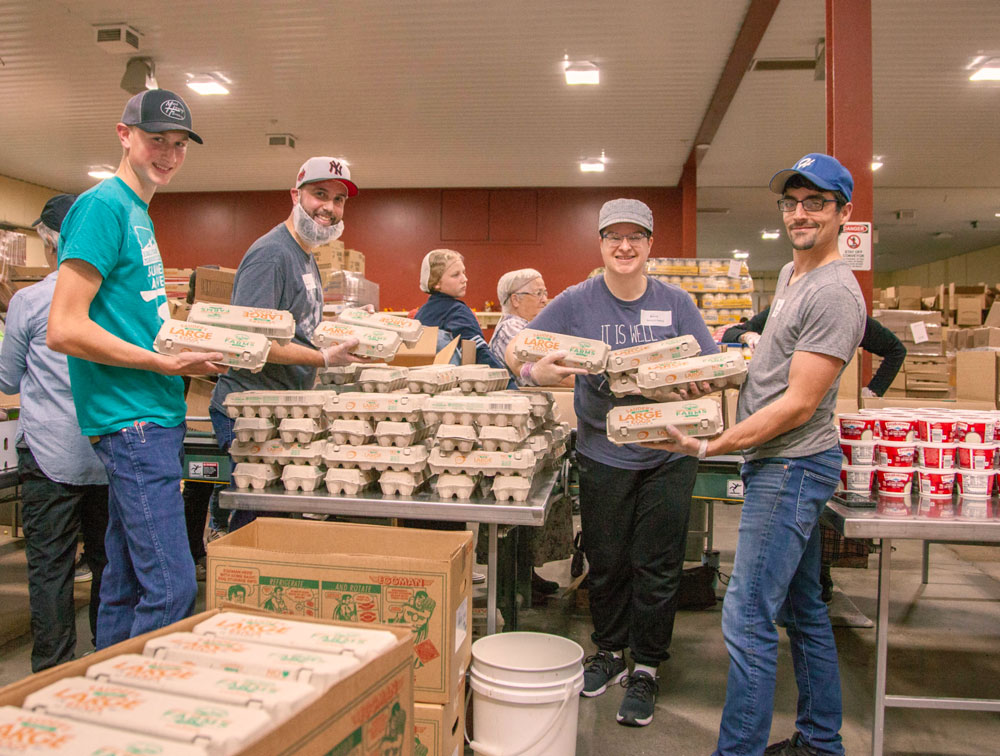 volunteer families packing food at Blessings of Hope warehouse