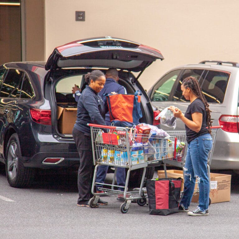 people loading food into a vehicle